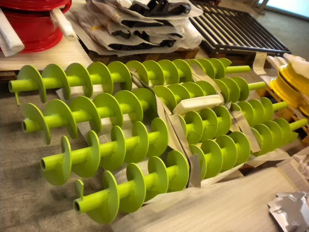 Große Metallkonstruktion wird in einer Fabrik von einem Kran angehoben.