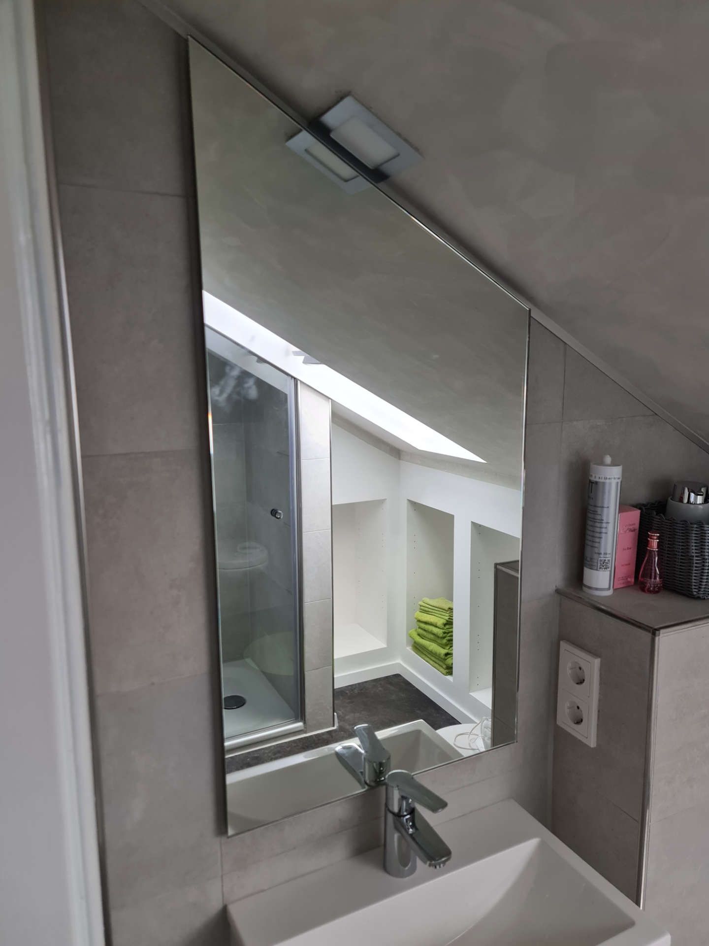 Spiegel im Badezimmer angepasst an die Dachschräge mit Beleuchtung