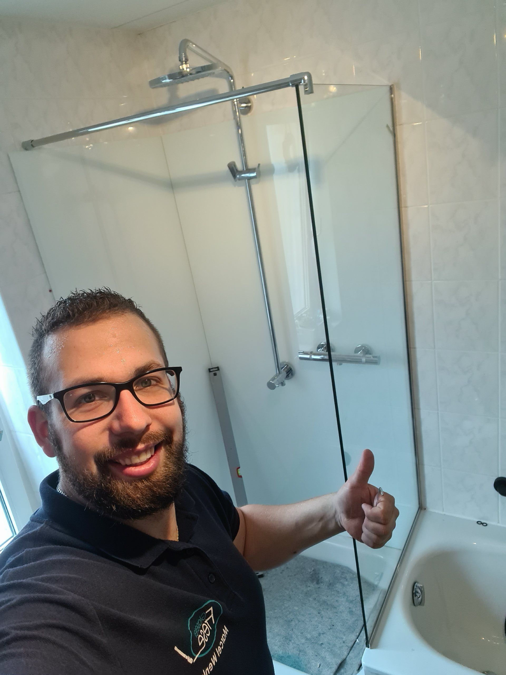 Ein Mann mit Brille zeigt in einem Badezimmer den Daumen nach oben