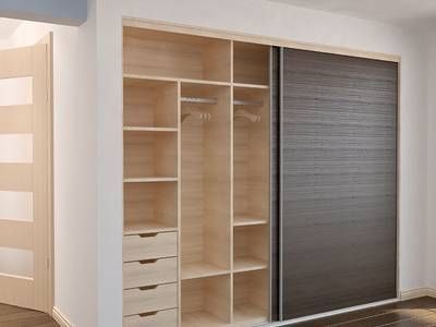 Dressing ouvert avec des étagères et des tiroirs, ainsi qu’une grande porte coulissante grise.