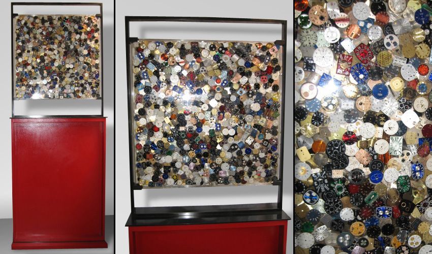 Une sculpture carrée vue de face avec un socle rouge