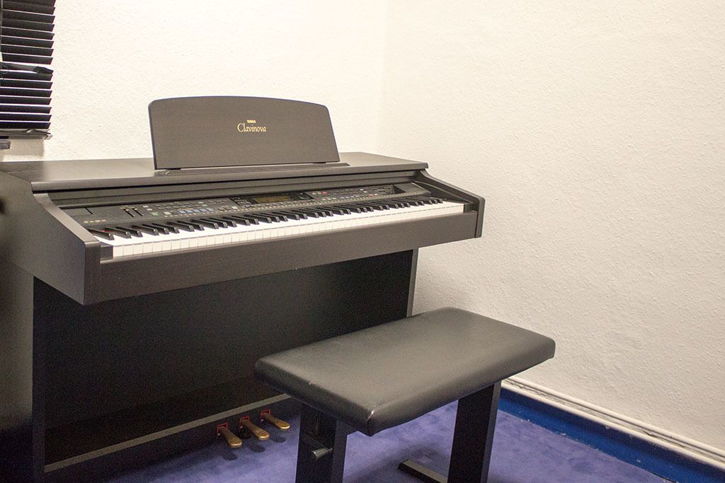 Ein Klavier mit einer Bank daneben in einem Raum