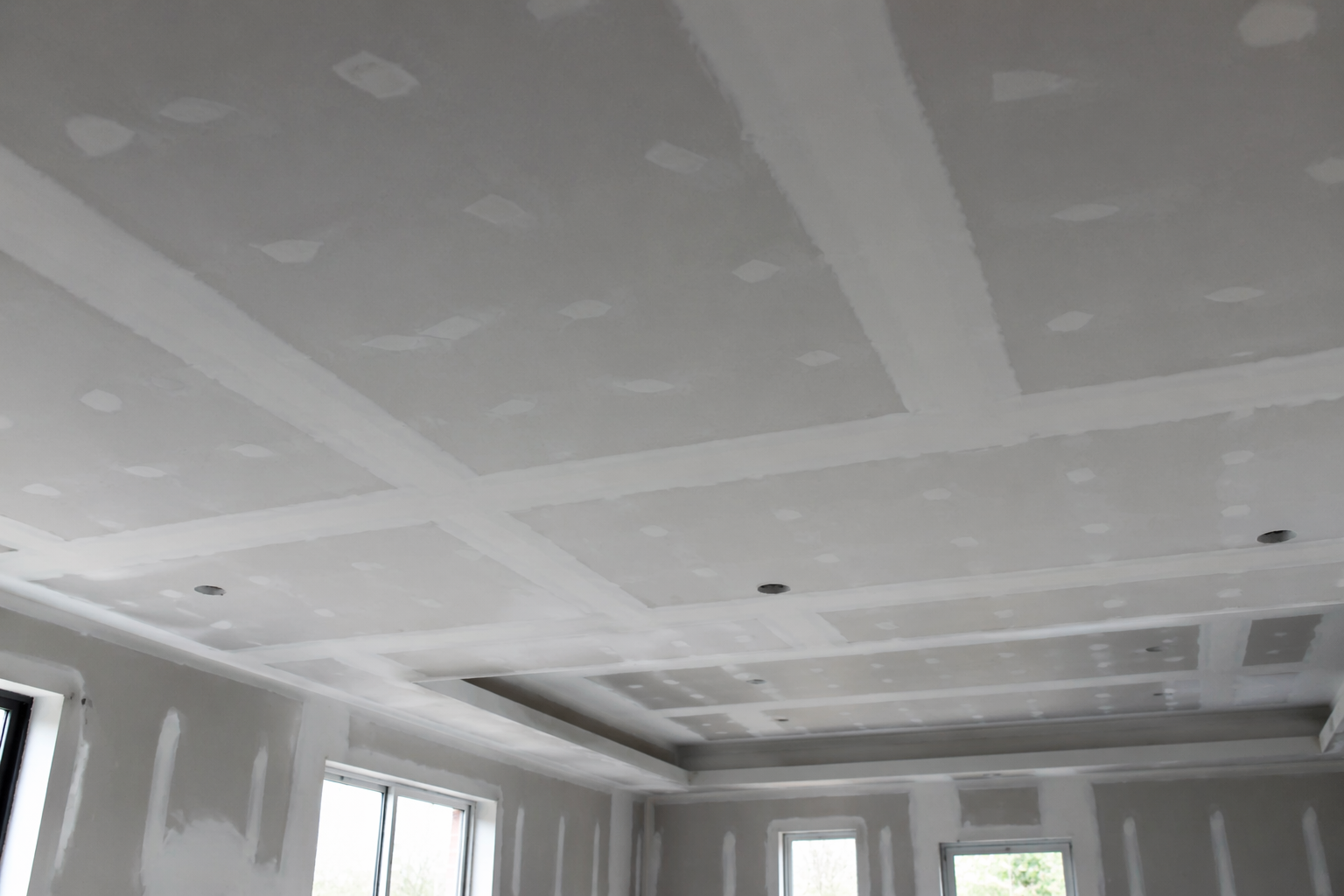 Pièce intérieure en construction avec des panneaux de plaques de plâtre, des outils, un échafaudage.