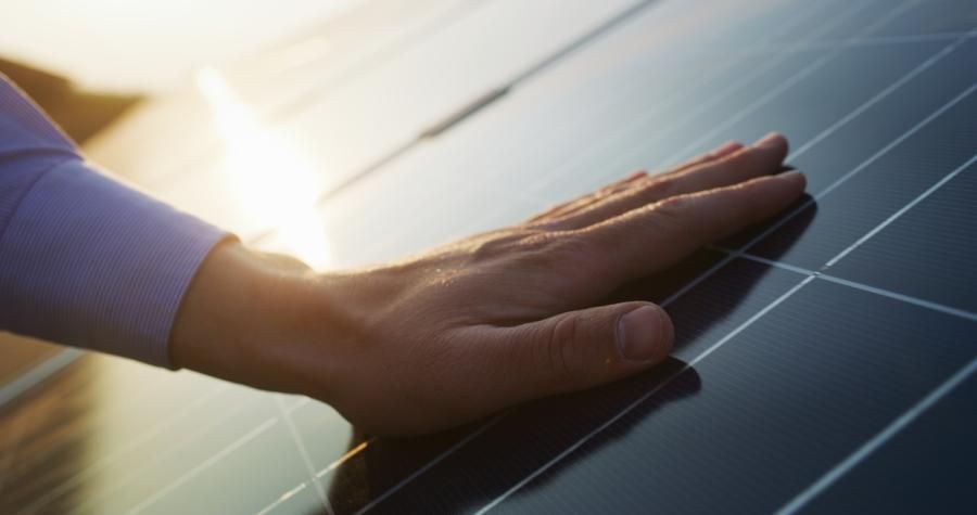 Hand berührt ein Solarpaneel