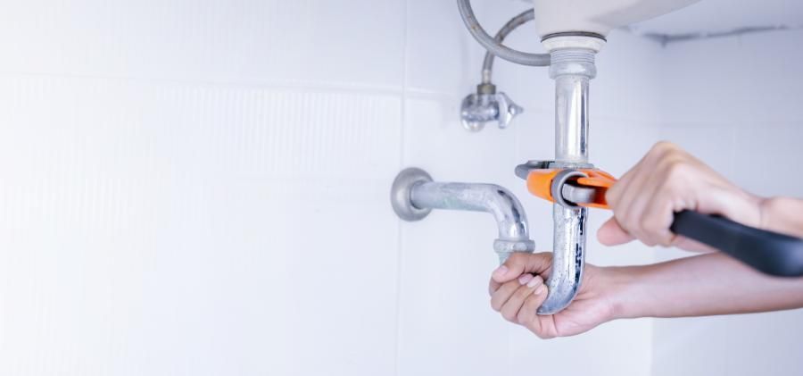 Handwerker repariert Leck an Wasserrohren