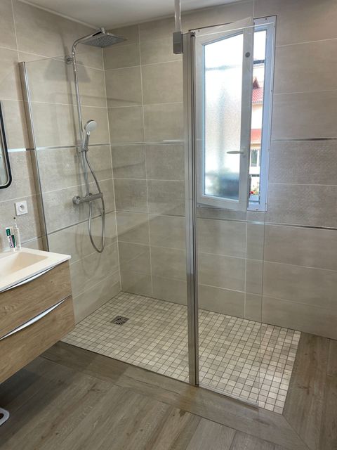 Une baignoire d'angle et une douche à côté
