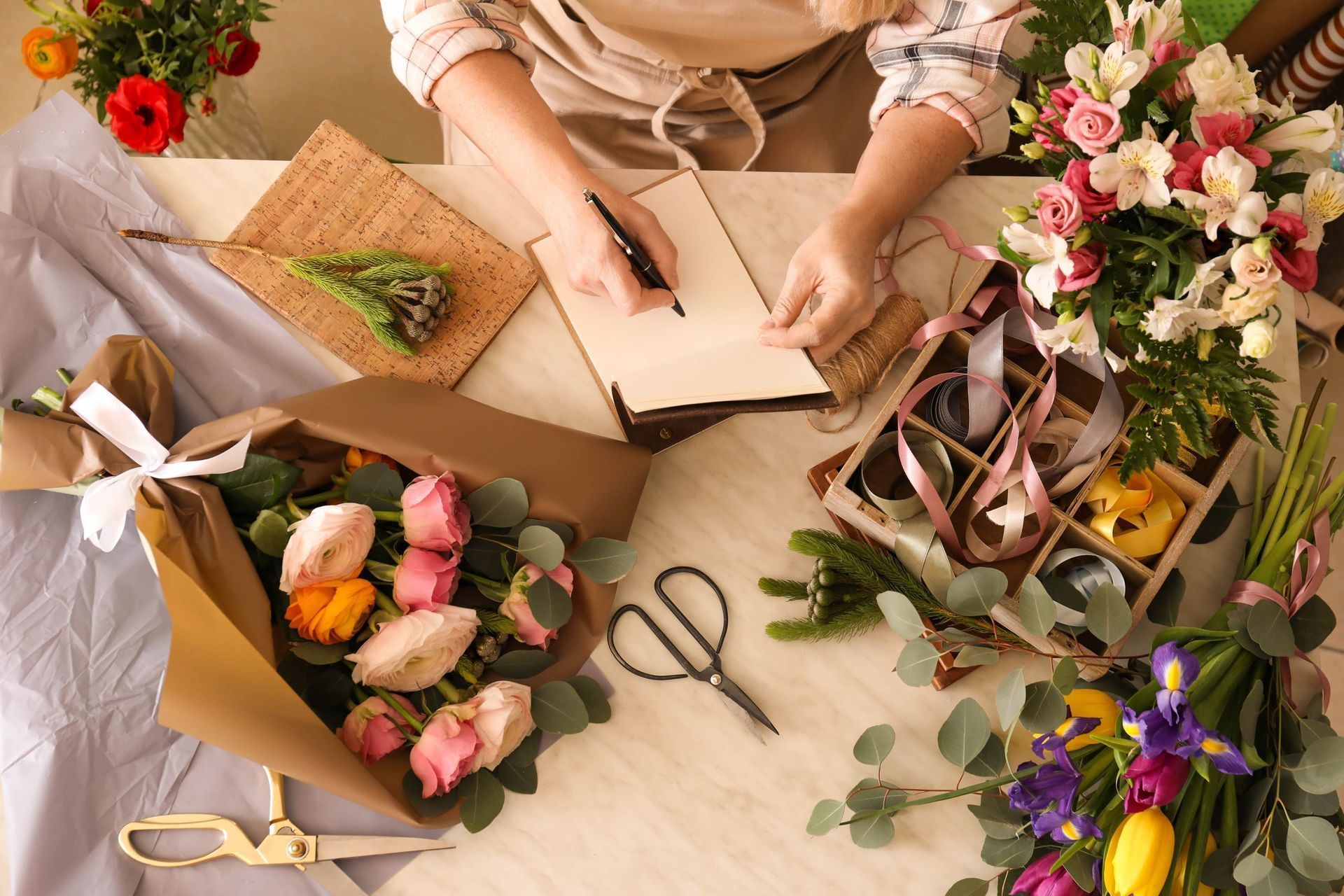 Élégante table dressée en extérieur avec des fleurs roses, des touches de blanc et un centre de table en forme de cage à oiseaux.