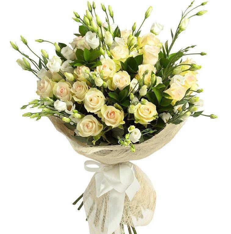 Bouquet de roses jaune clair et de fleurs blanches, enveloppé dans un filet beige et noué avec un ruban blanc.