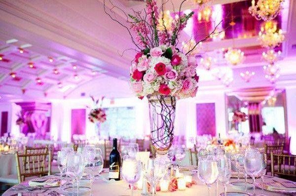 Réception de mariage élégante avec centres de table et décorations florales roses.