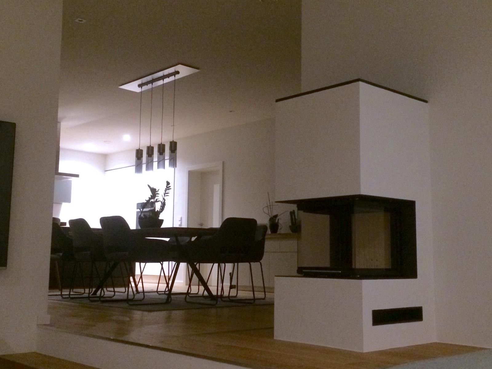 Blick auf Wohnbereich mit Kamin und Tisch