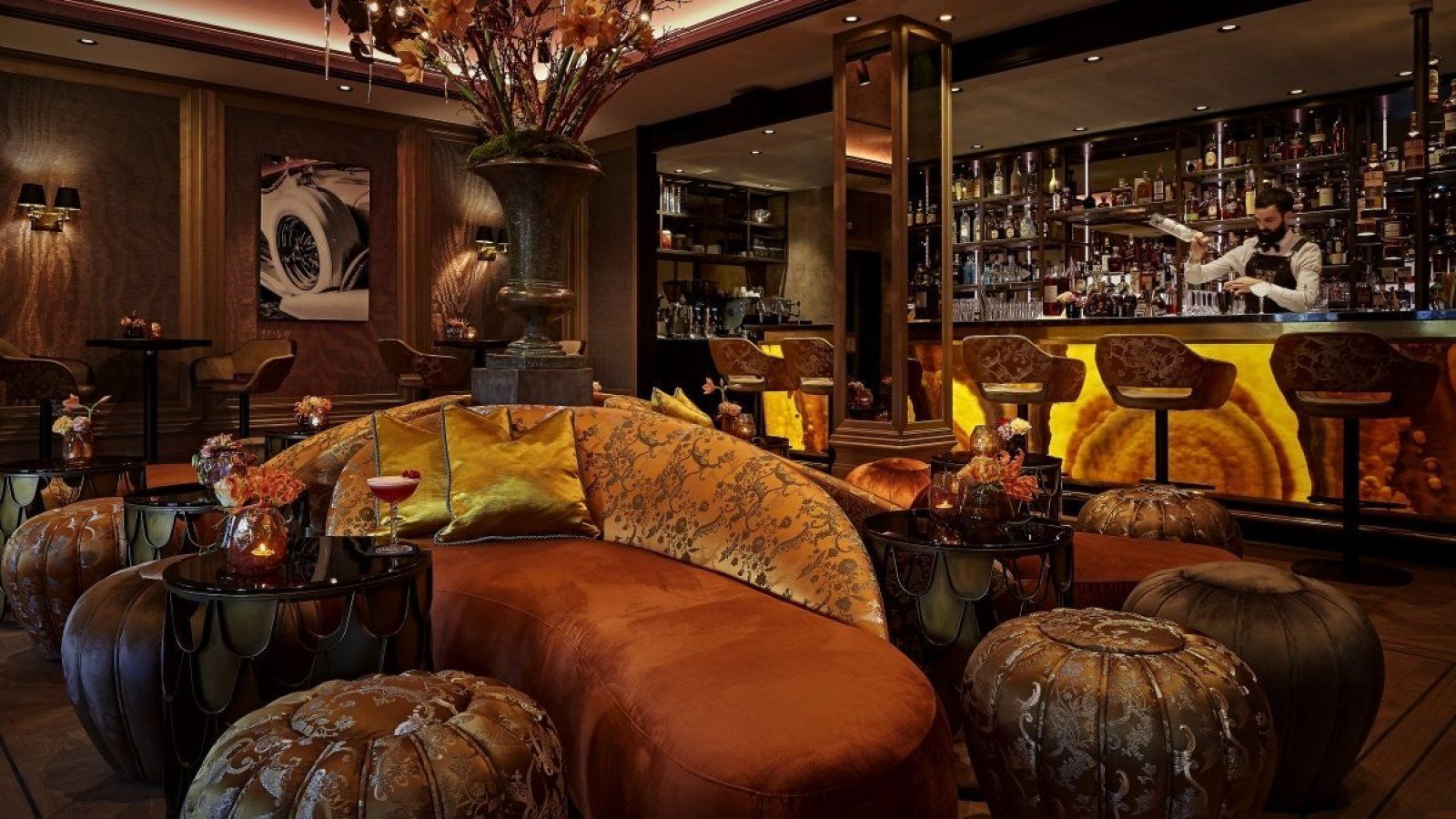 Luxurious lounge with leather seating, warm amber lighting, and a backlit bar