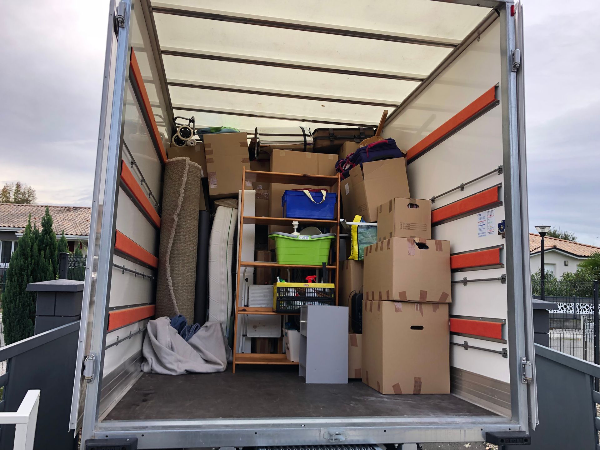 Tas de cartons, tapis et étagères en bois dans camion ouvert