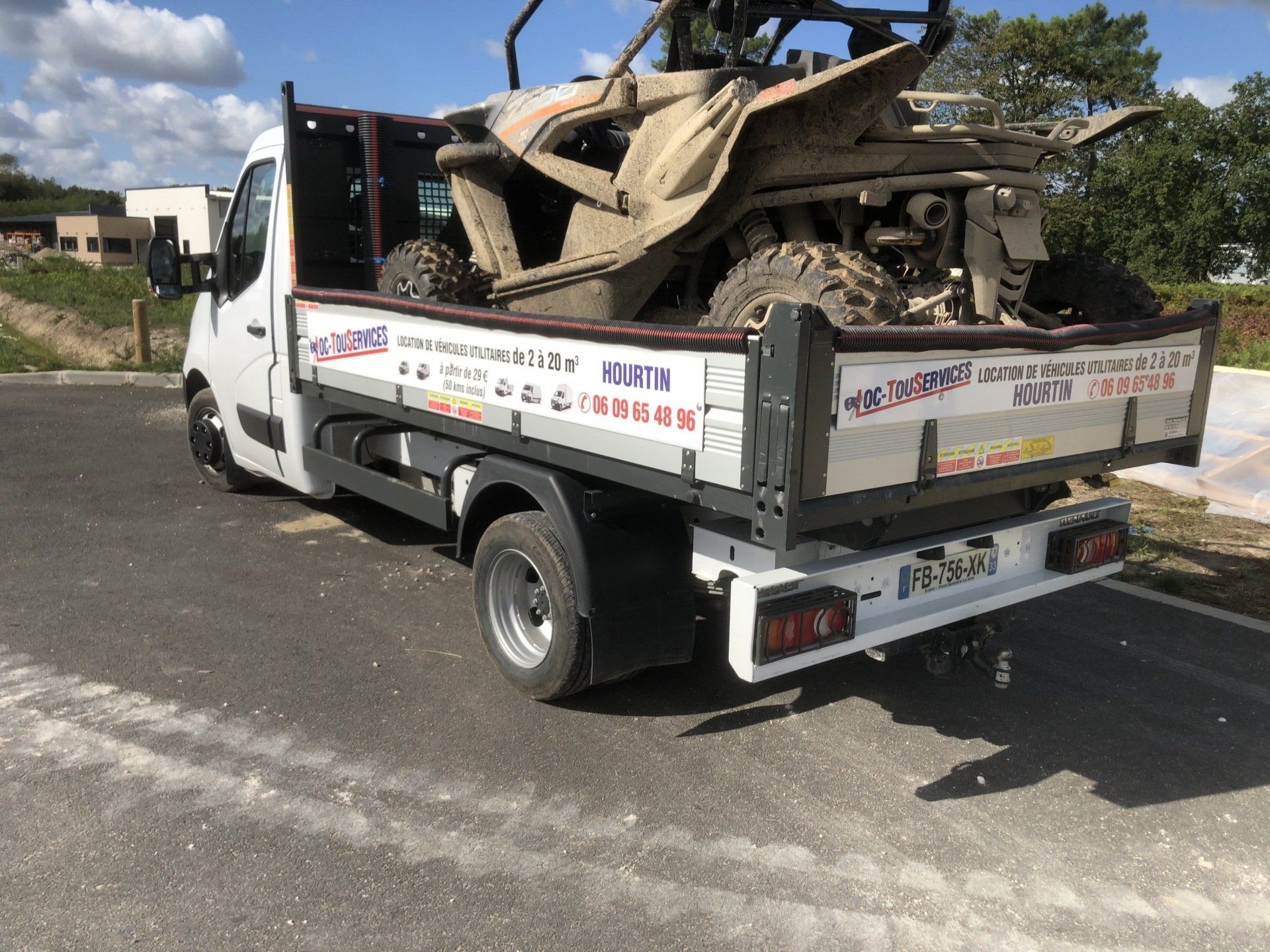 Quad boueux et sale dans camion-benne avec flocage Loc-TouServices