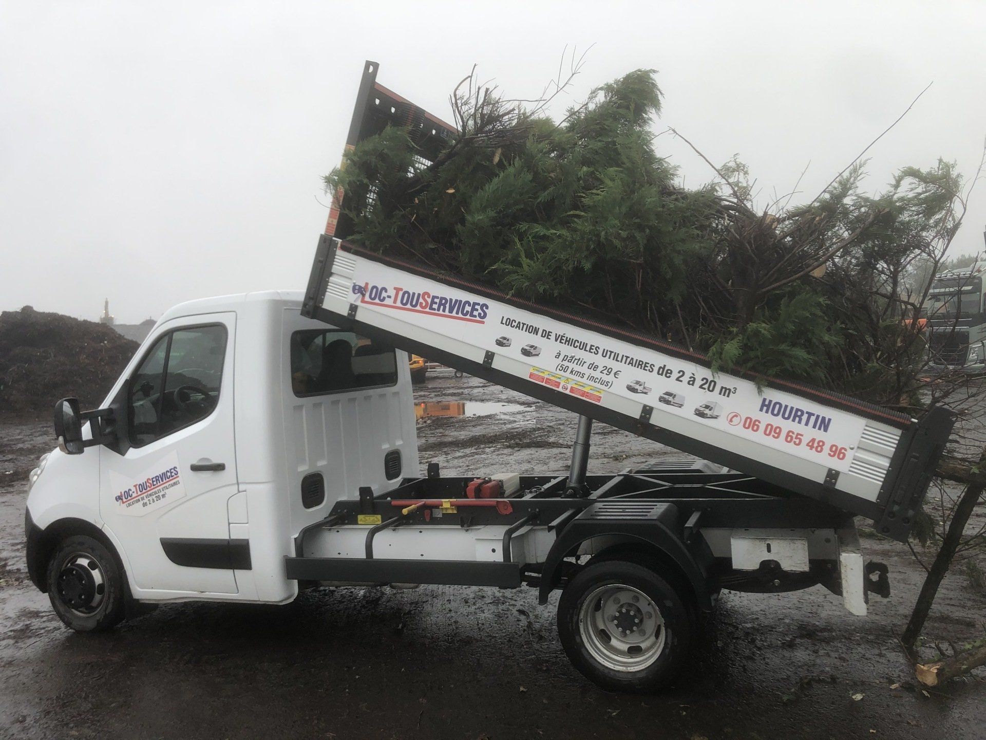 Camion-benne avec déchets verts en train d'être descendu