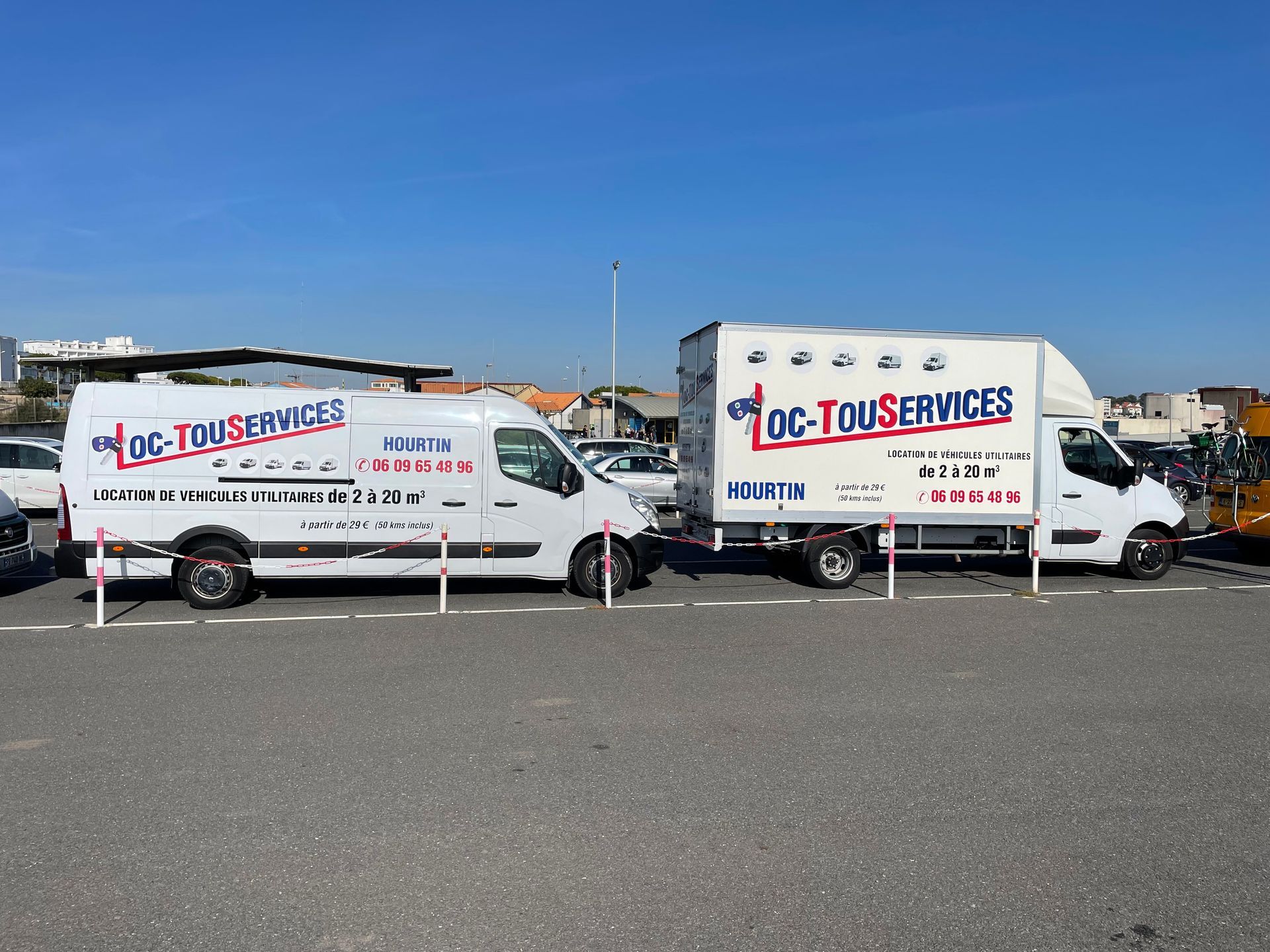 Fourgon et camionnette garées l'une dernière l'autre avec LocTouServices écrit dessus