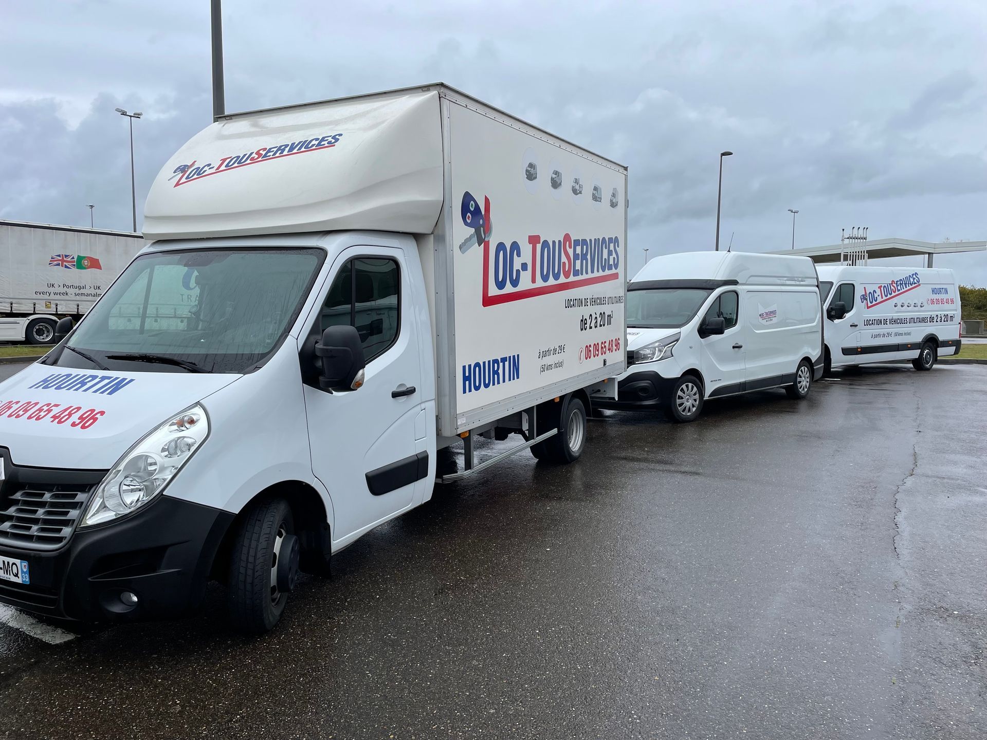 Suite de fourgons blancs avec un flocage Loc-Tous-Servics