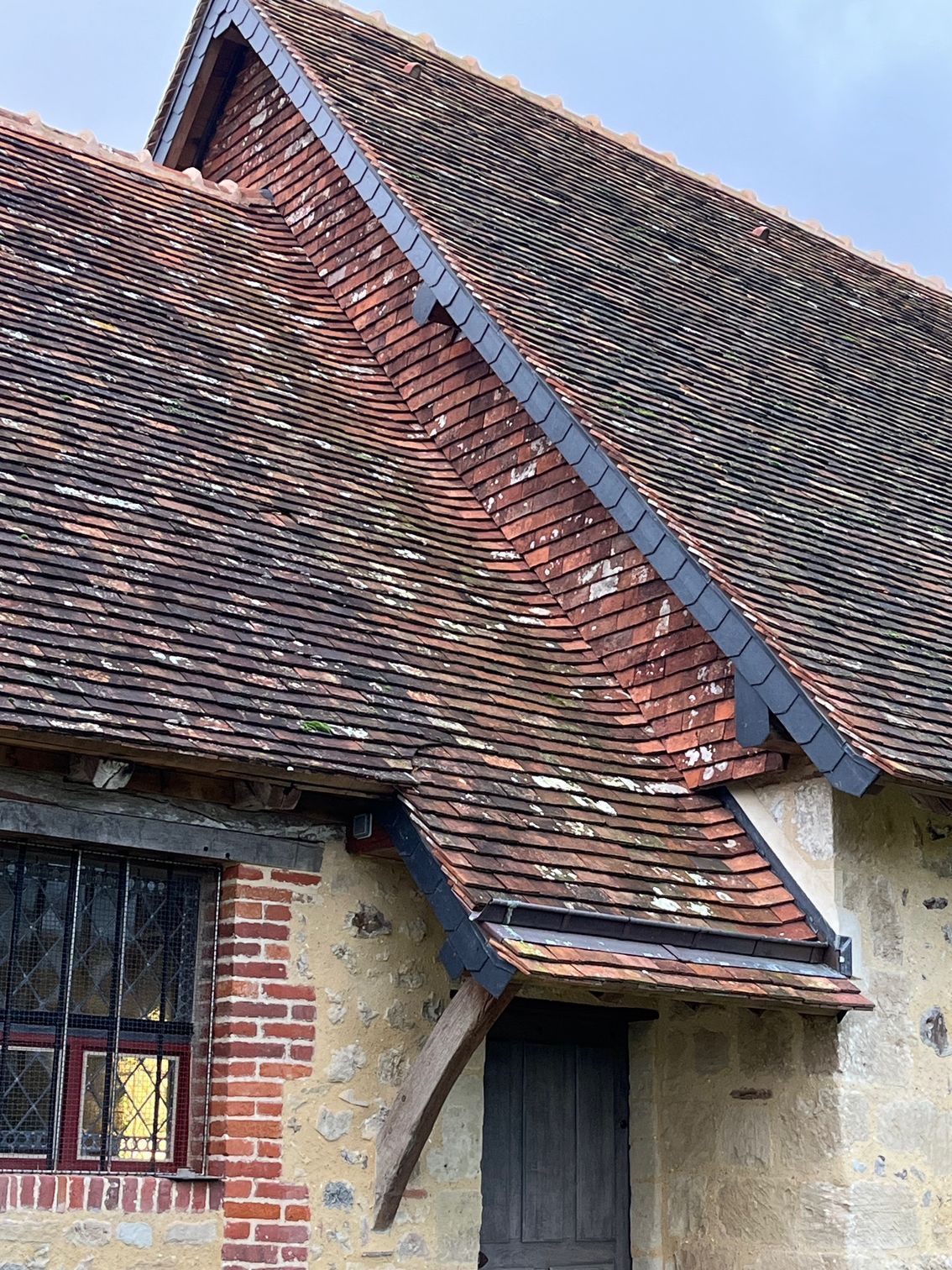 Installation de solins et d'ardoises sur une toiture en tuiles