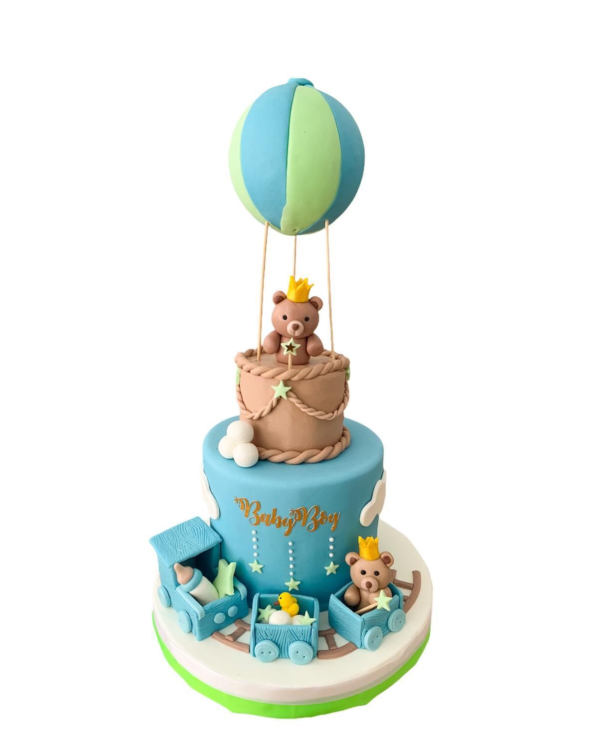 Un pastel de baby shower con ositos de peluche y un globo aerostático.
