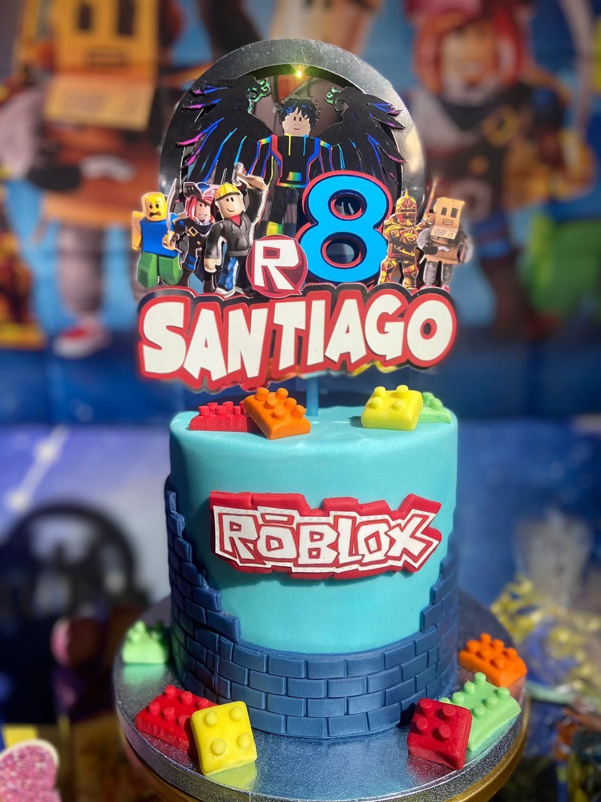 Un pastel de cumpleaños para santiago con un adorno de pastel de roblox.