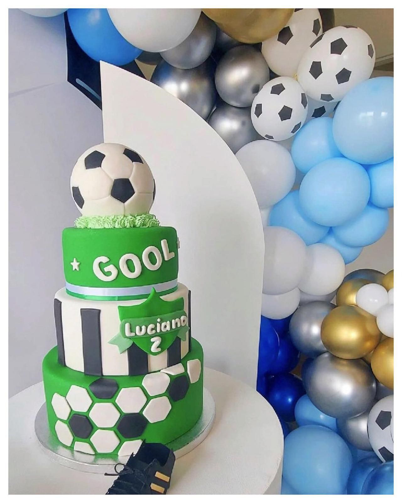 Un pastel verde y blanco con un balón de fútbol encima.