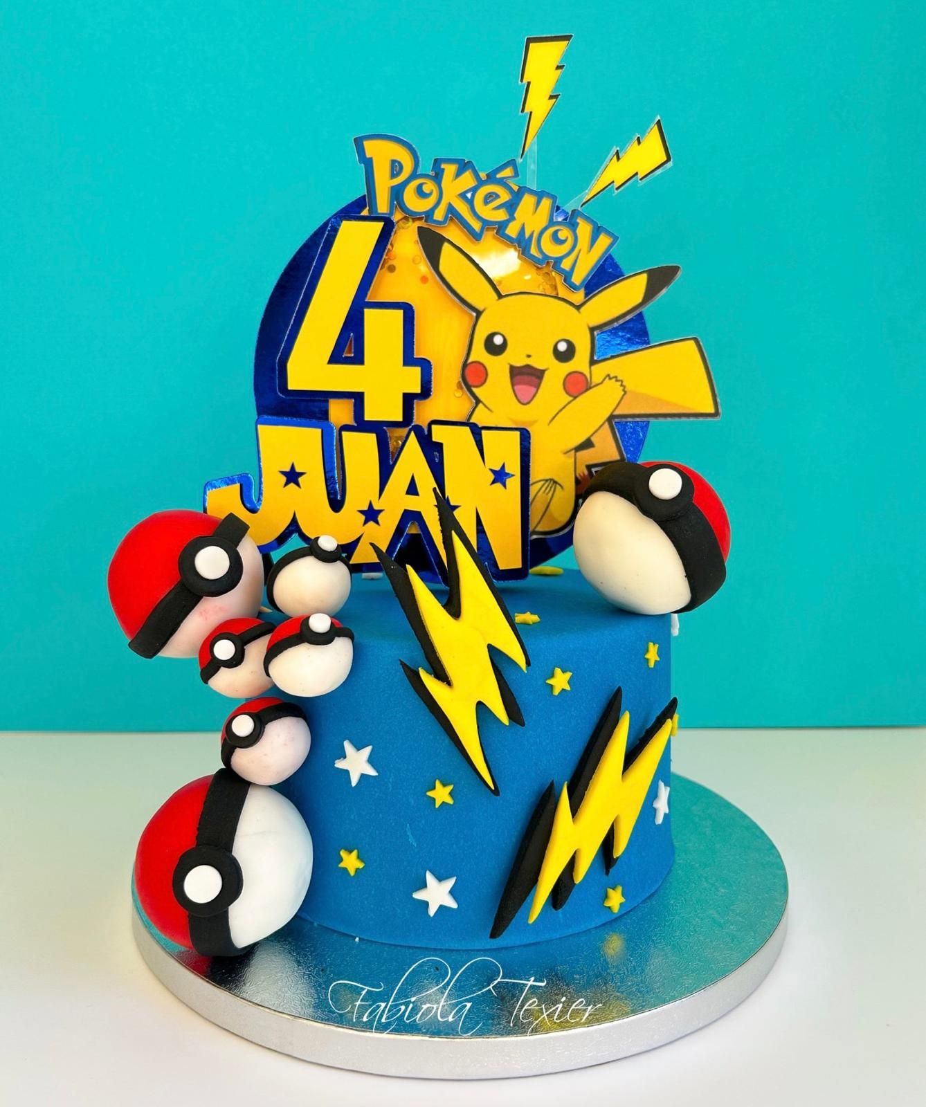 Un pastel azul con Pikachu y bolas de Pokémon encima.