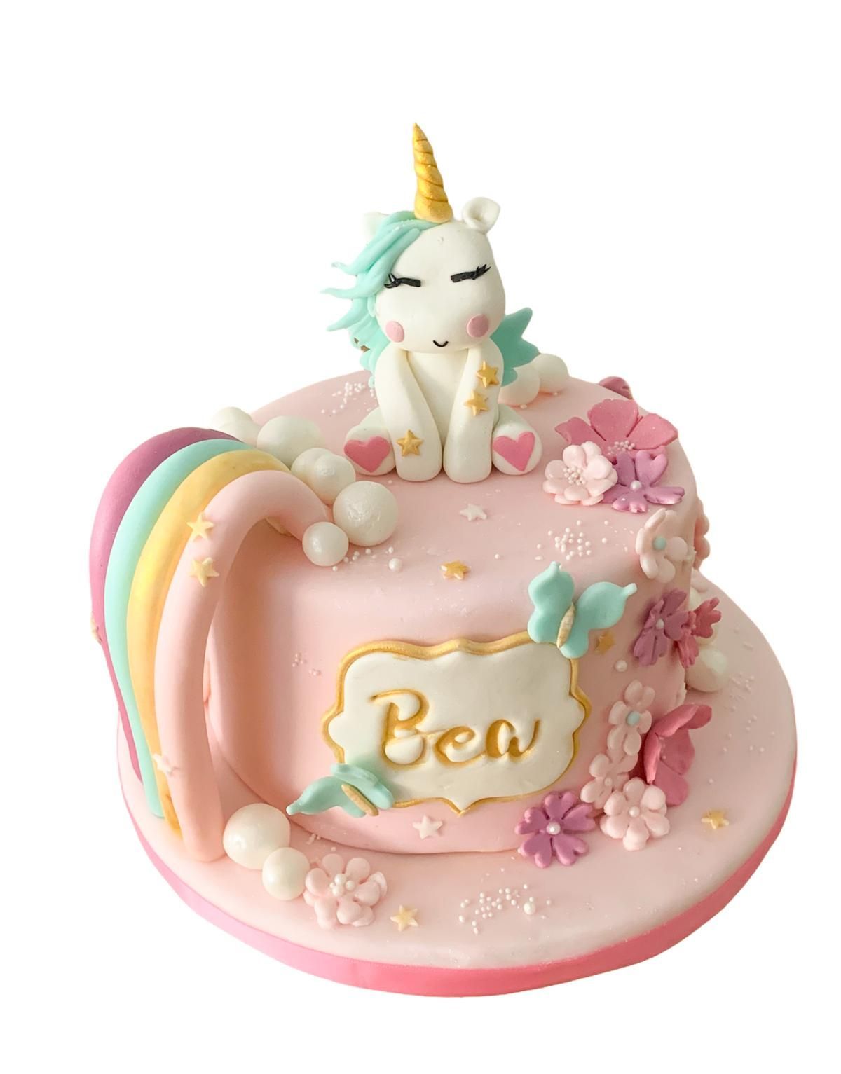 Un pastel rosa con un unicornio encima.
