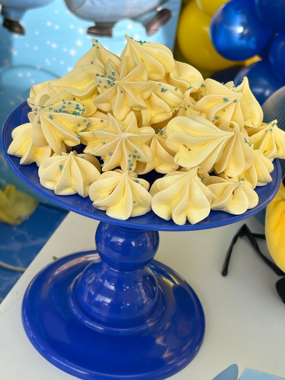 Un plato azul cubierto con glaseado amarillo y chispas azules.