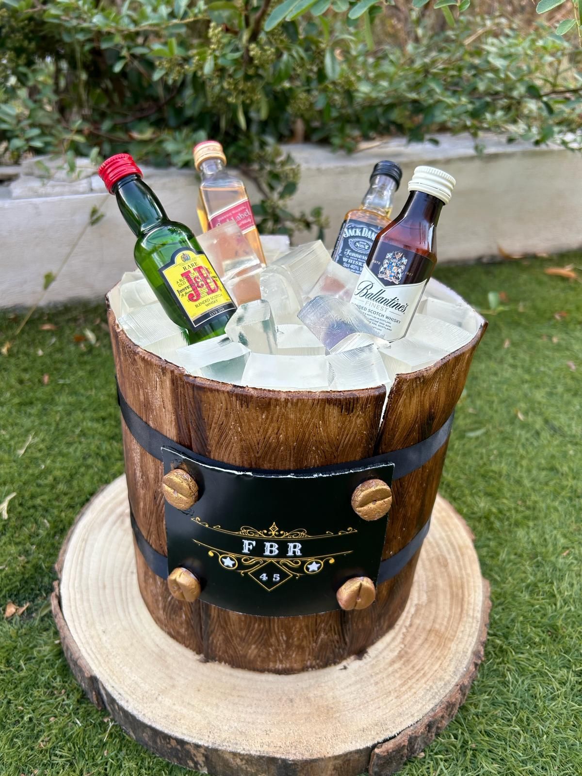 Un cubo de madera lleno de hielo y botellas de licor.