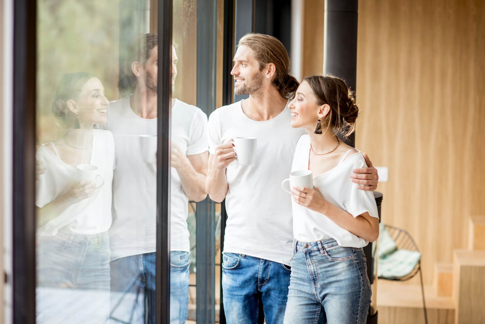 A man and a woman are standing next to each other looking out of a window.