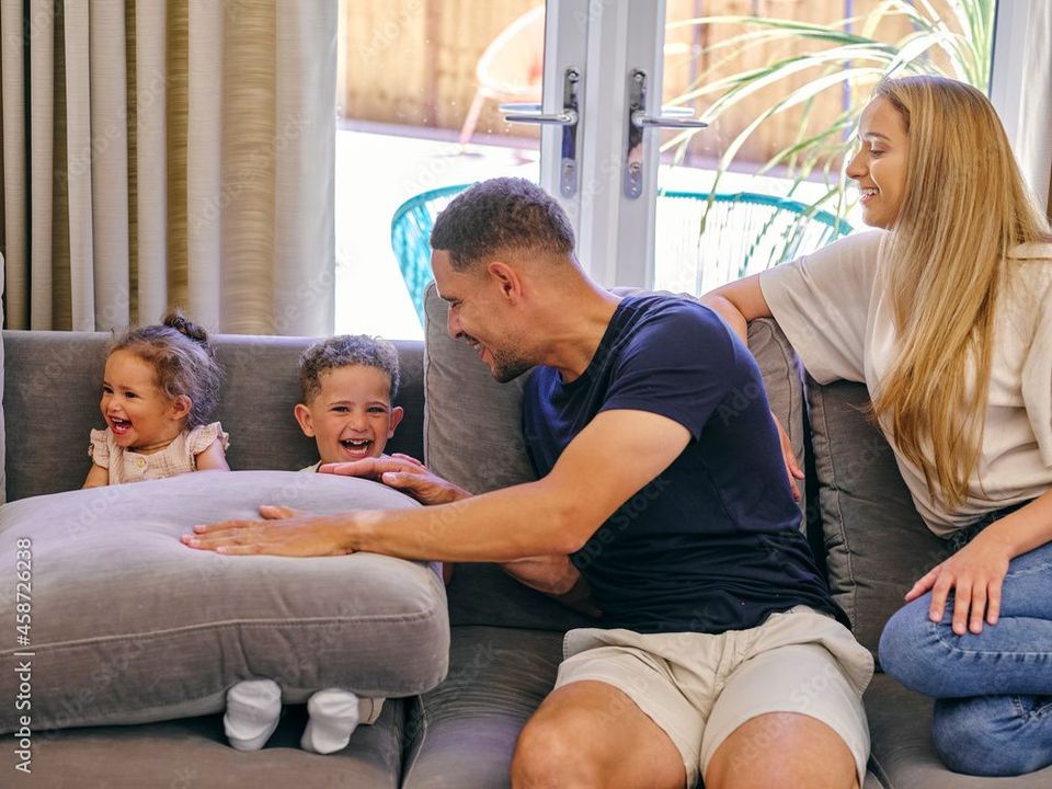 A man and woman are sitting on a couch with two children.