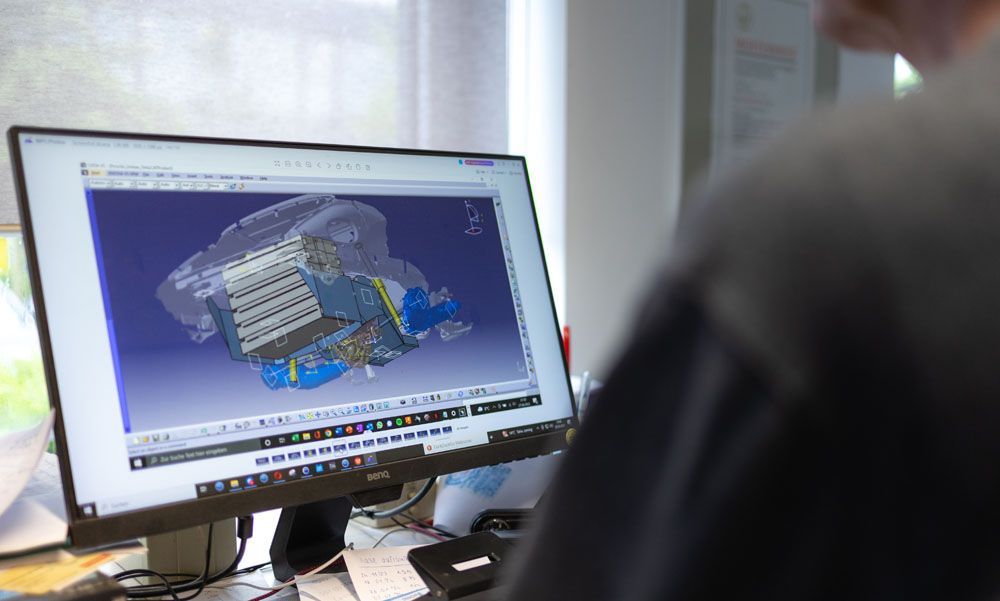 Ein Mann sitzt an einem Schreibtisch und schaut auf einen Computerbildschirm.