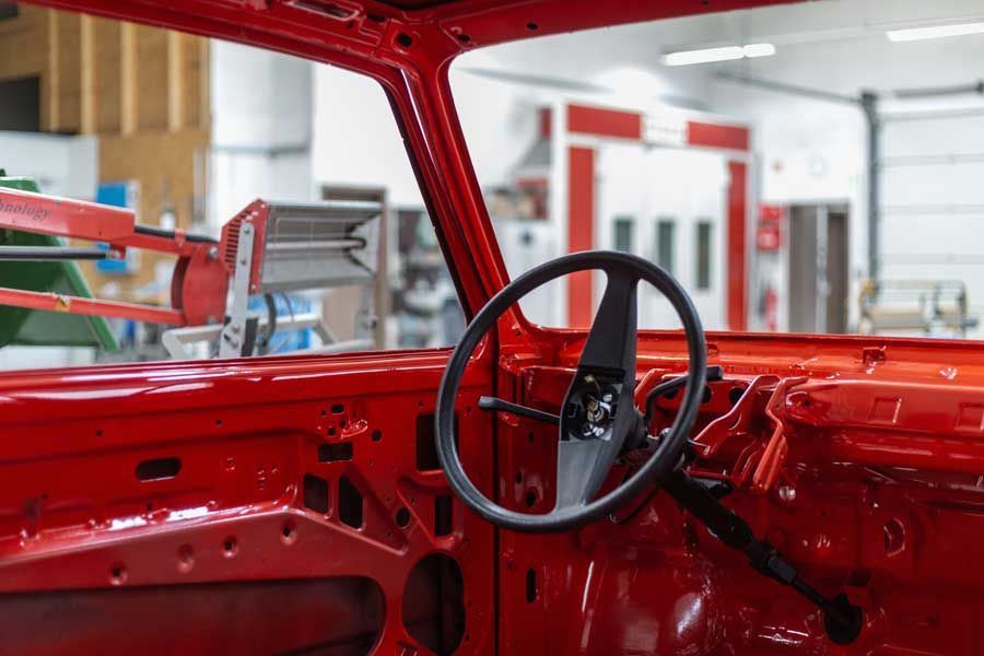 Die Innenausstattung eines roten Autos wird in einer Garage gebaut.