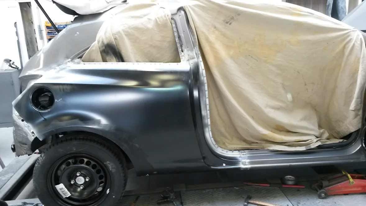 Ein schwarzes Auto wird in einer Garage lackiert