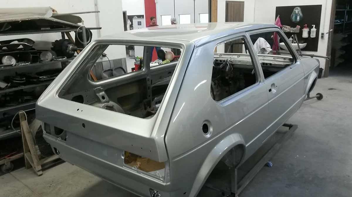 In einer Garage wird ein silbernes Auto gebaut