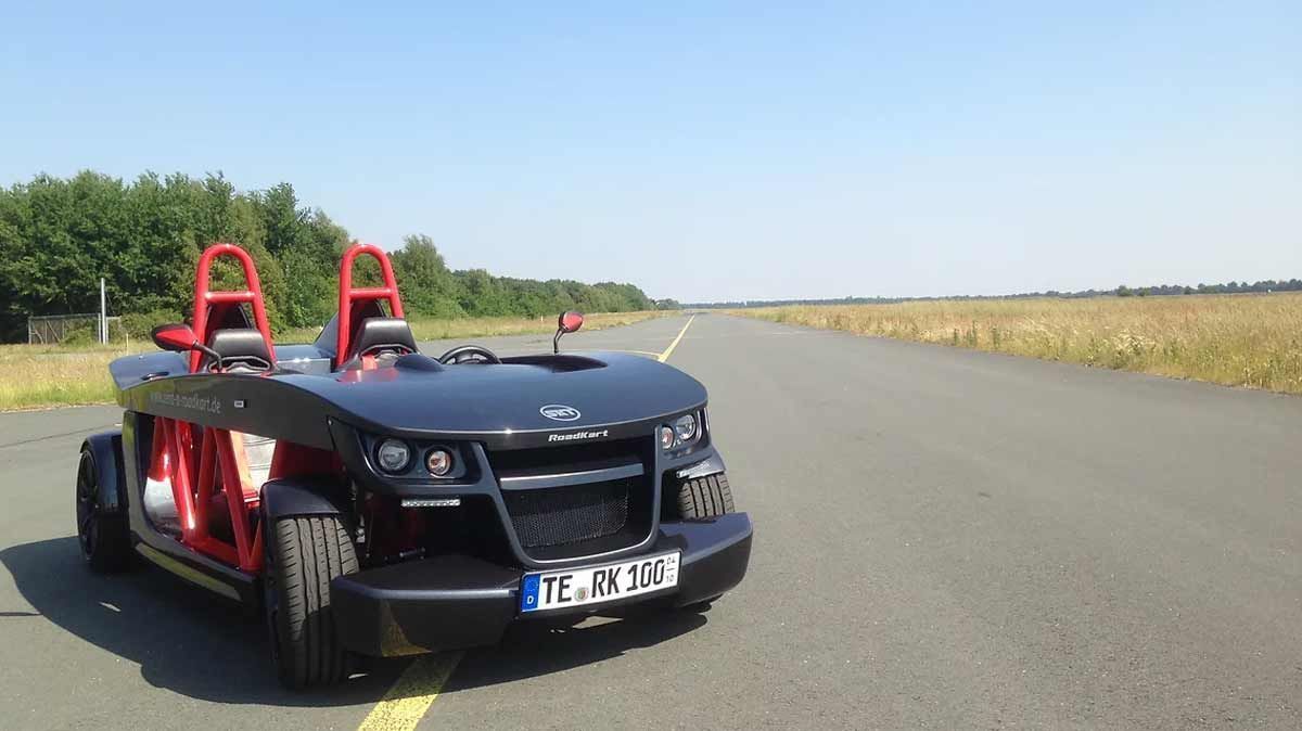 Ein schwarz - roter Sportwagen ist am Straßenrand geparkt.