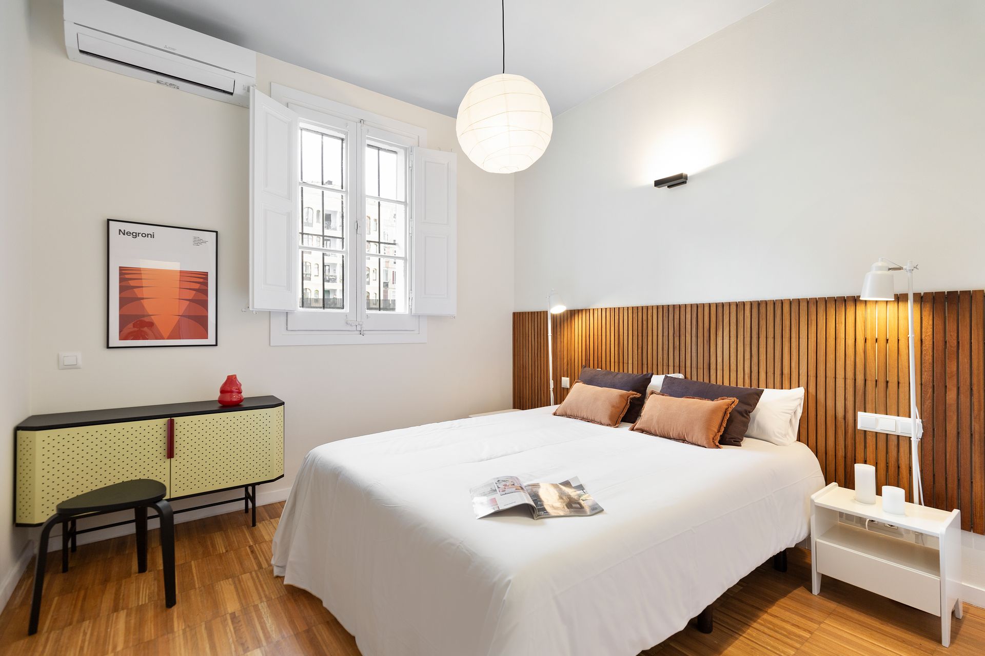 A bedroom with a bed , nightstand , and window.