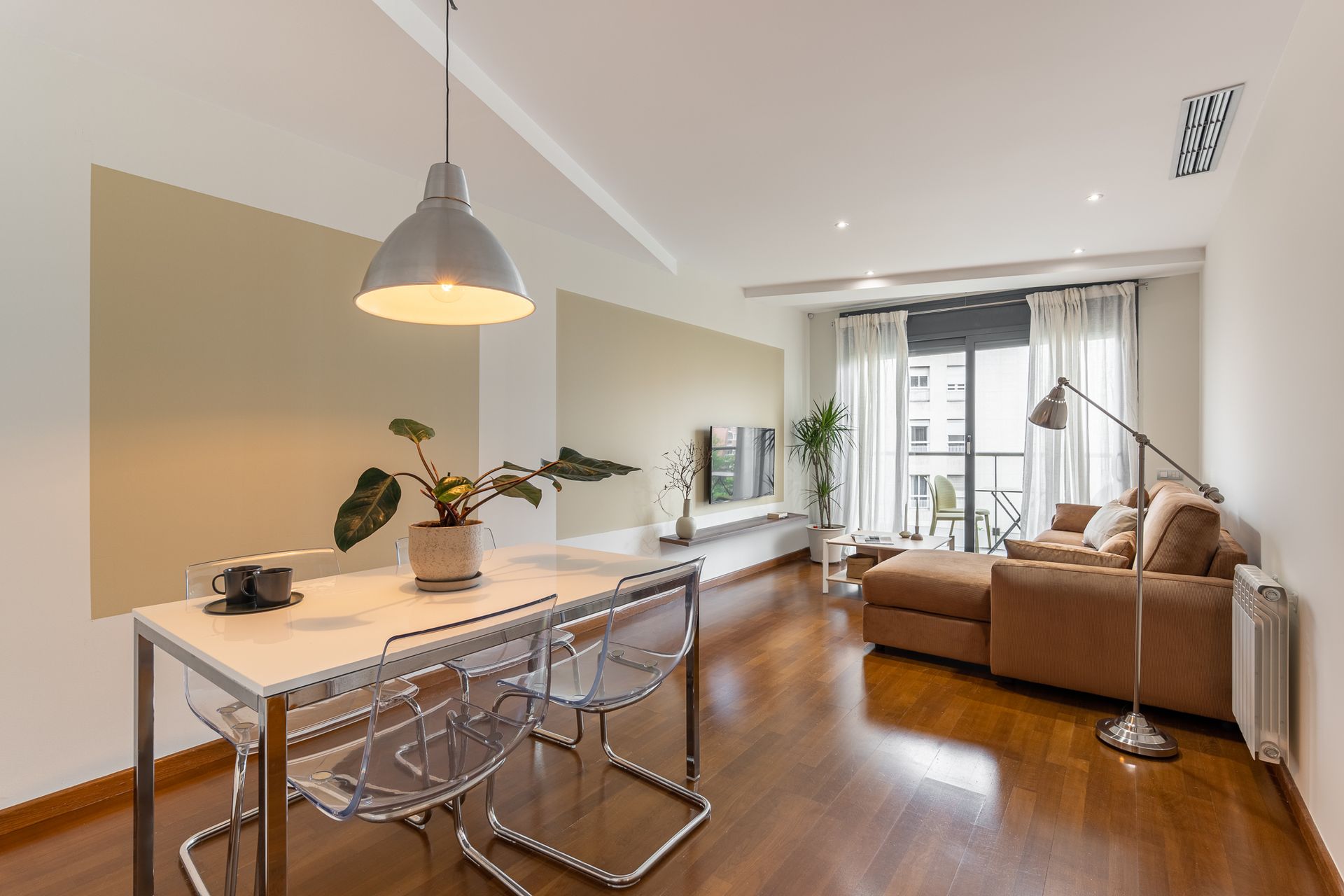 A living room with a table and chairs and a couch.