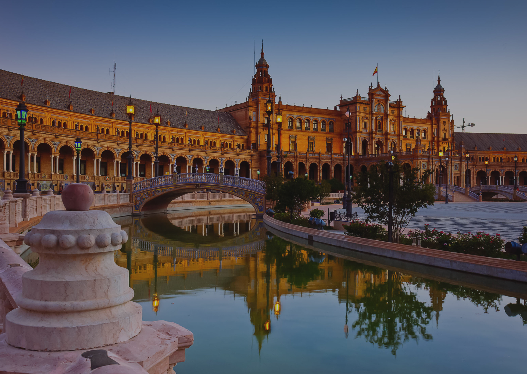 A large building with a bridge over a body of water in front of it.