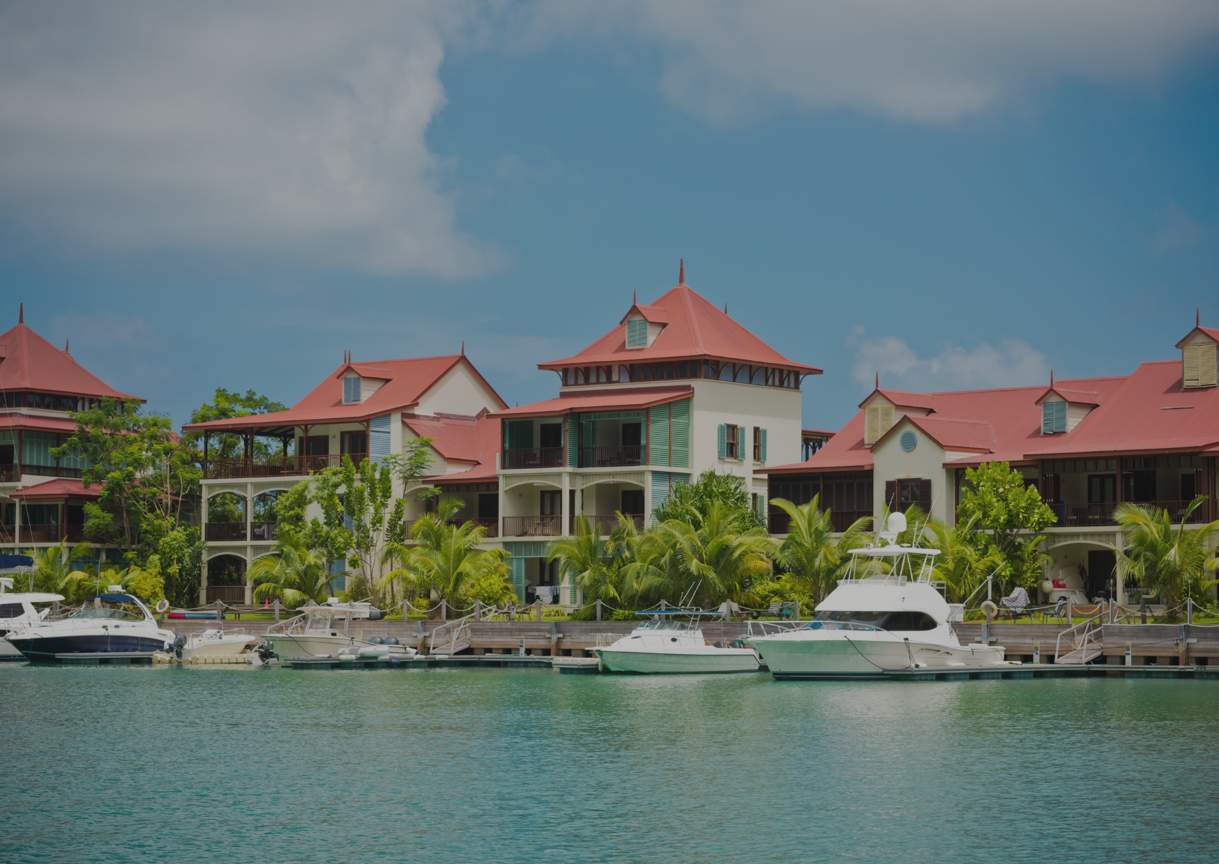 A row of buildings with red roofs are next to a body of water