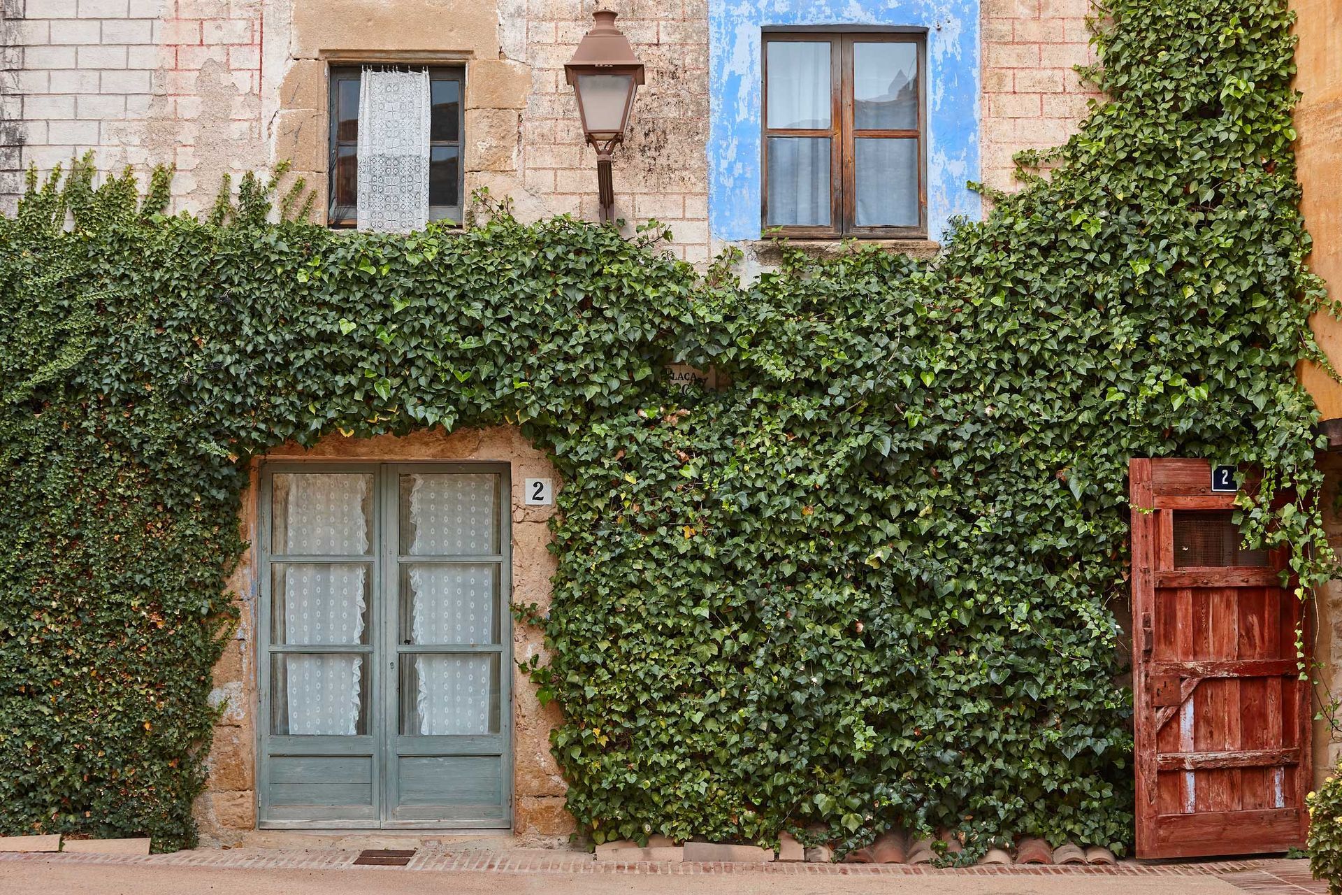 A brick building with ivy growing on the side of it