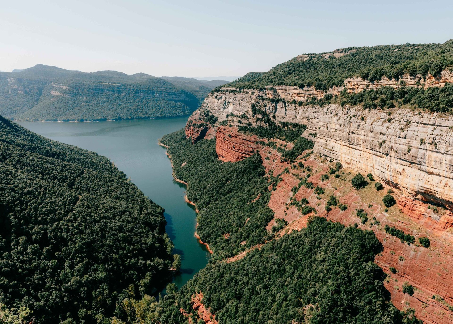 An aerial view of a river surrounded by mountains and trees.
