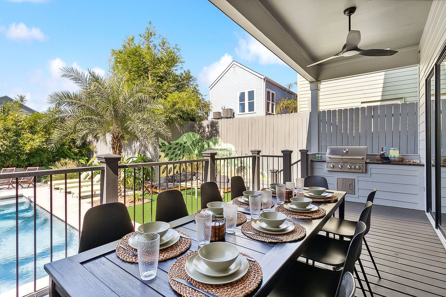 A patio with a table and chairs and a ceiling fan