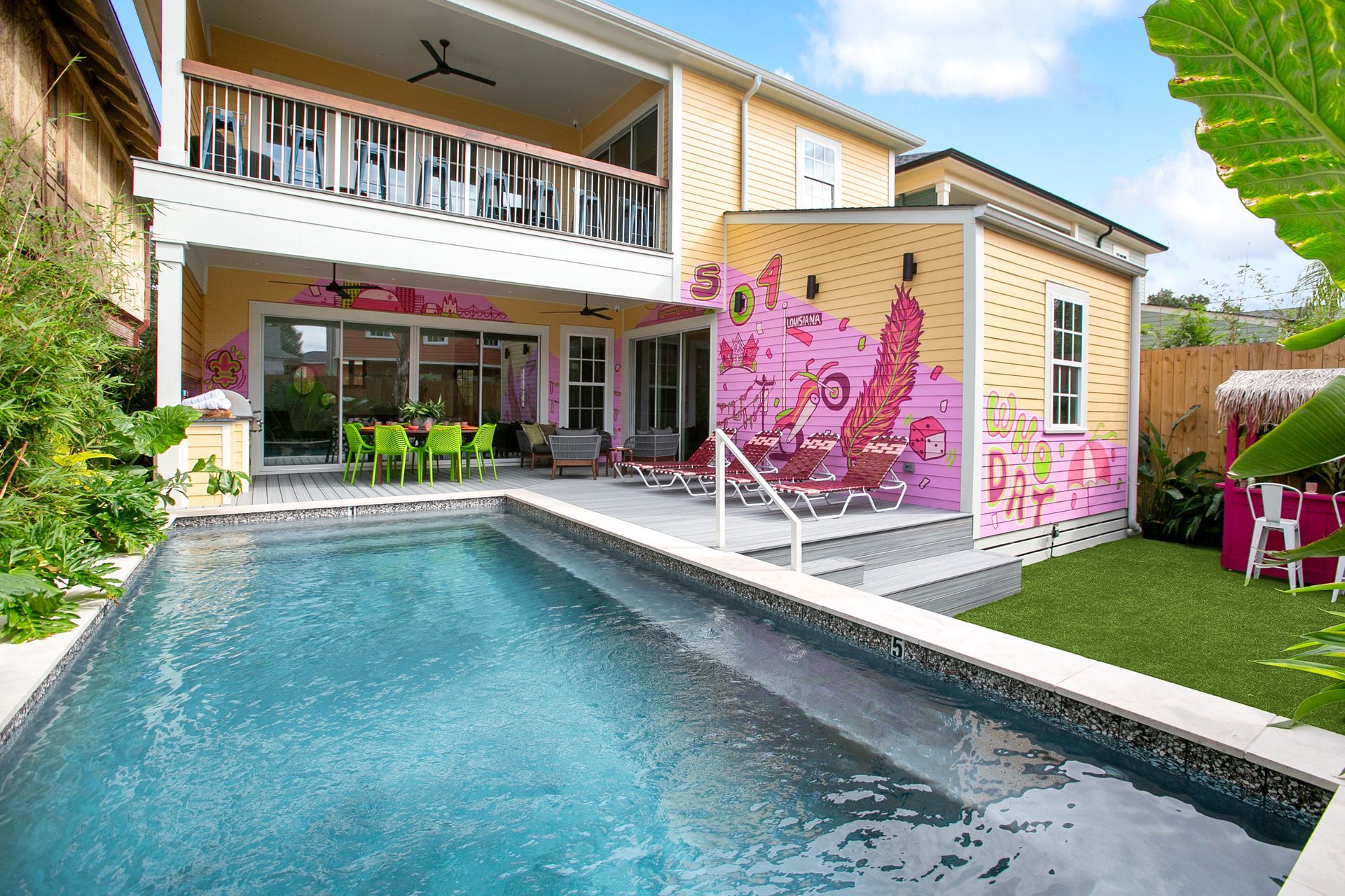 A house with a large swimming pool in front of it