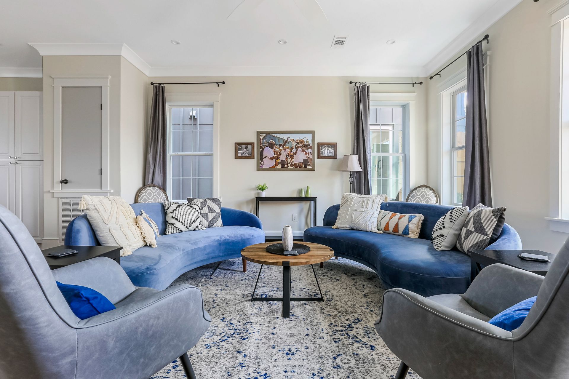 A living room with a blue couch and gray chairs