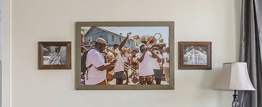A painting of a band playing instruments is hanging on a wall.
