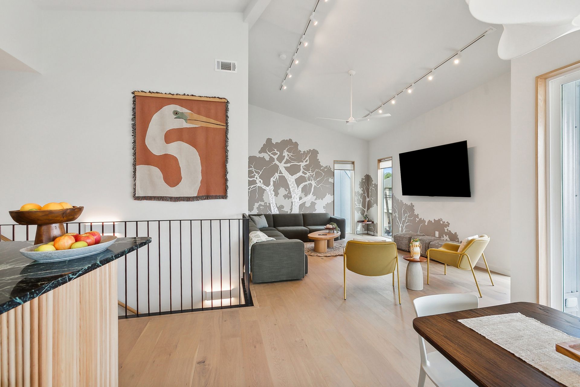 A living room with a couch , chairs , a table and a television.