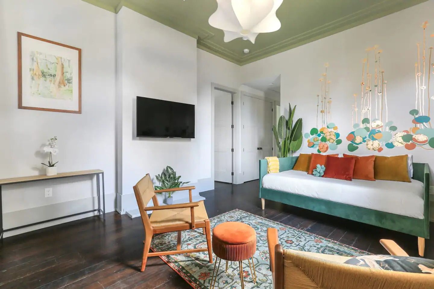 A living room with a couch , chairs , and a flat screen tv.