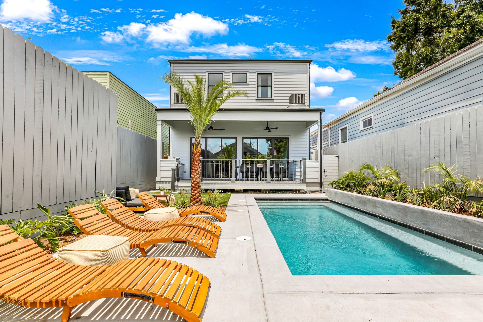 There is a large swimming pool in the backyard of a house.