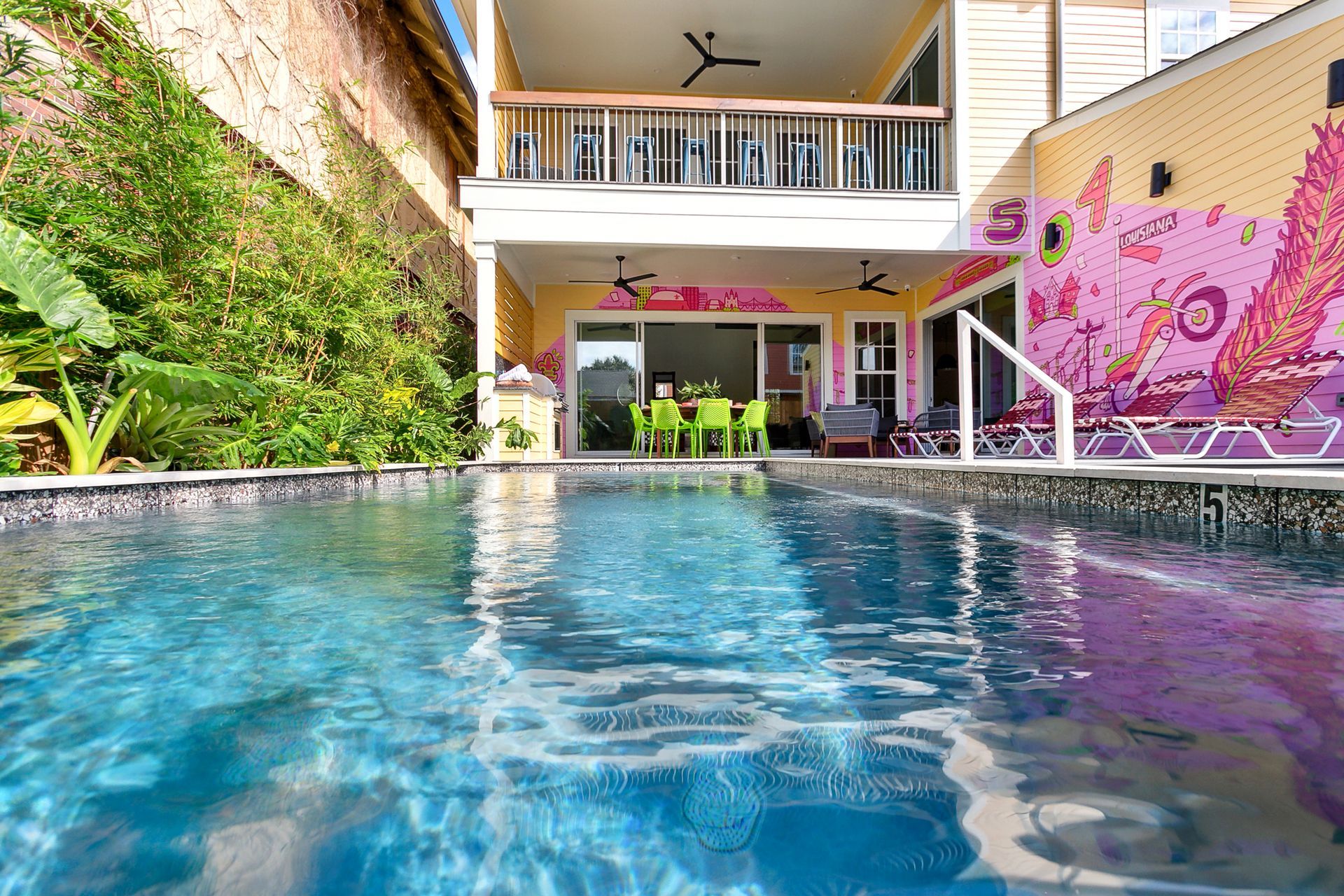 There is a large swimming pool in front of a house.