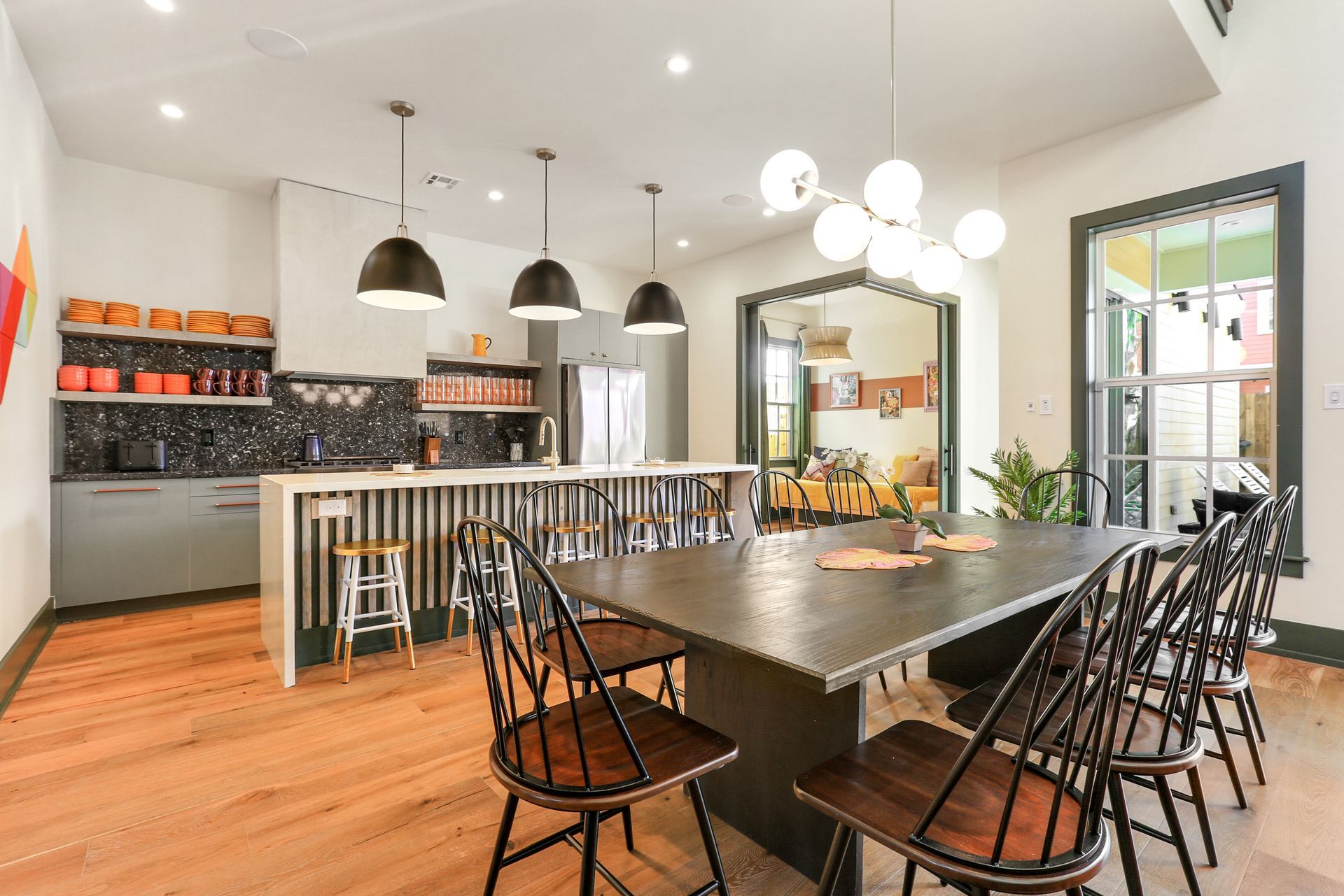 A large dining room table with chairs and a kitchen in the background.